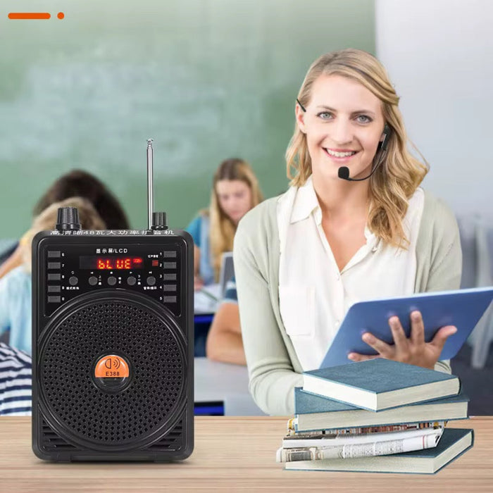 Woman in a classroom setting with a portable speaker and books.
