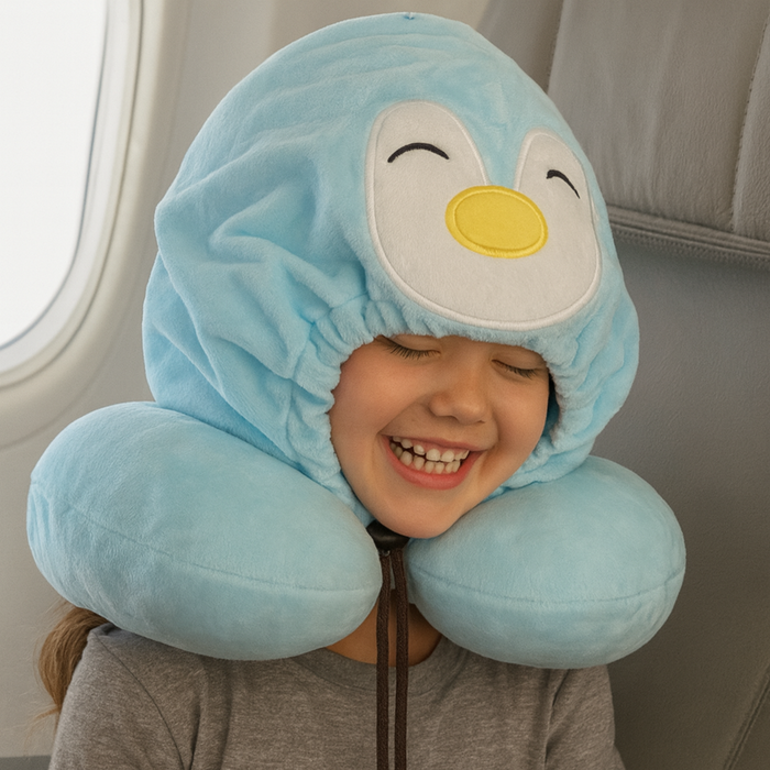 Child wearing a blue penguin-shaped neck pillow on an airplane.