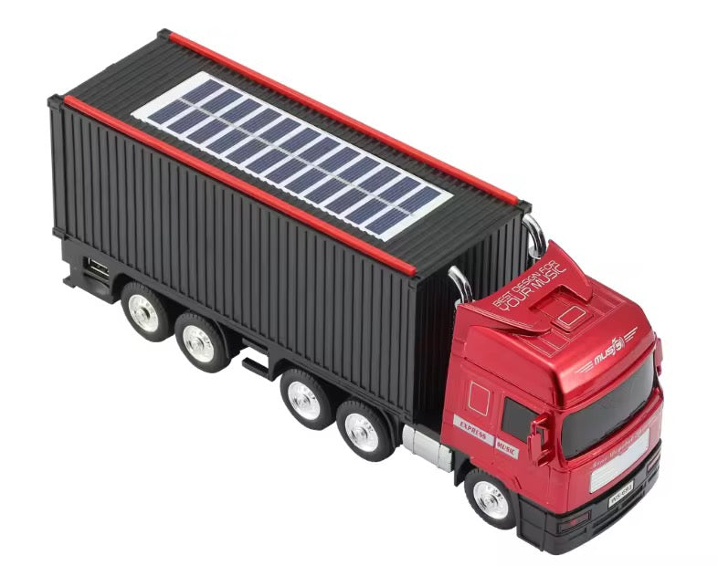 Model truck with a red cab and black trailer featuring solar panels on a white background