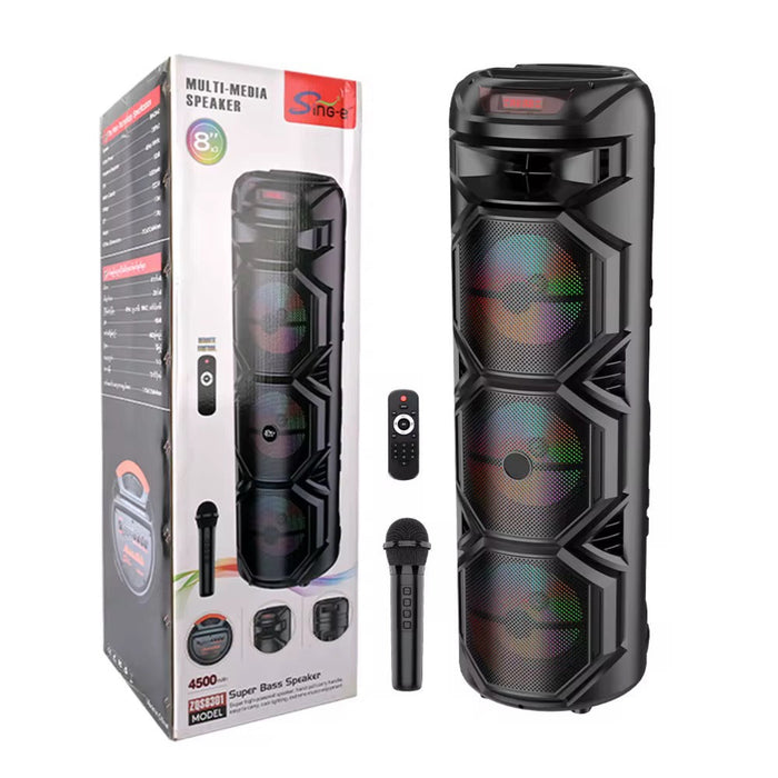 Black multimedia speaker with remote control and microphone, next to its packaging on a white background