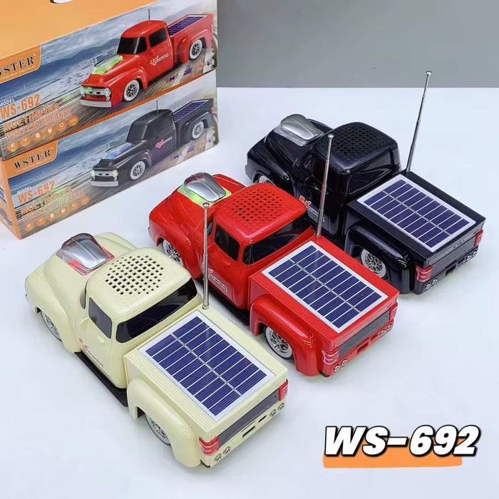 Four toy trucks with solar panels on a white surface, including a box in the background.