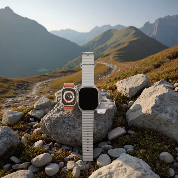 Smartwatches on rocks with a mountainous landscape in the background