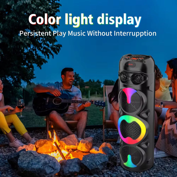 Portable speaker with colorful light display in front of a group of people around a campfire.