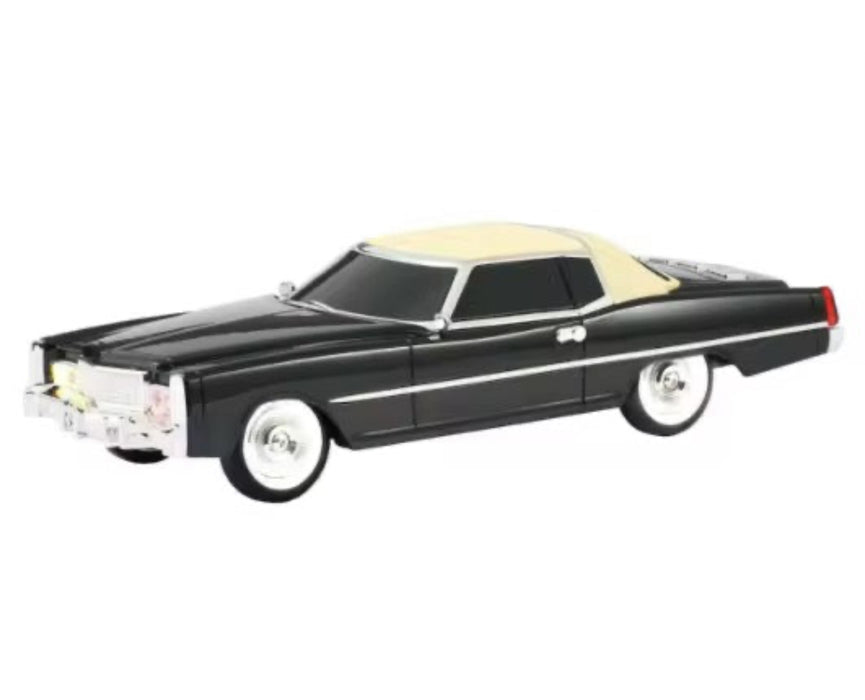 Model car with black body and beige roof on a white background