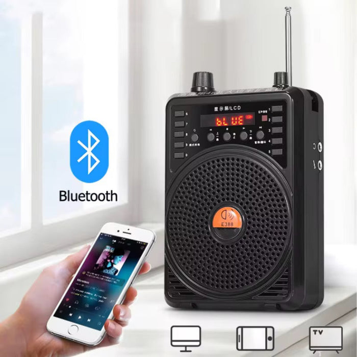 Black portable speaker with Bluetooth connectivity, held by a hand next to a smartphone.