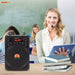 Woman in a classroom setting with a portable speaker and books.