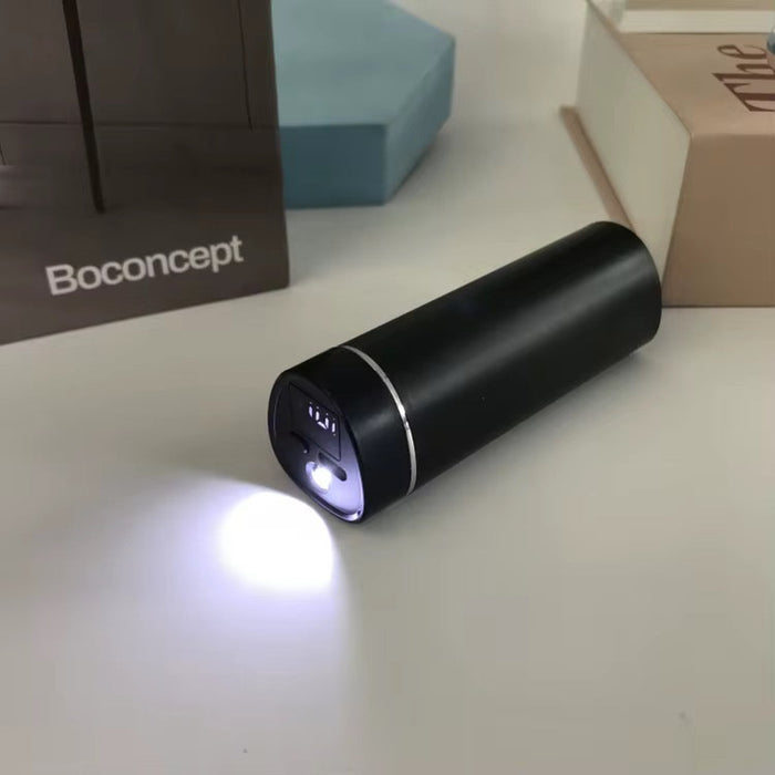 Black cylindrical light on a white surface with Boconcept branding in the background