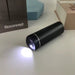 Black cylindrical light on a white surface with Boconcept branding in the background