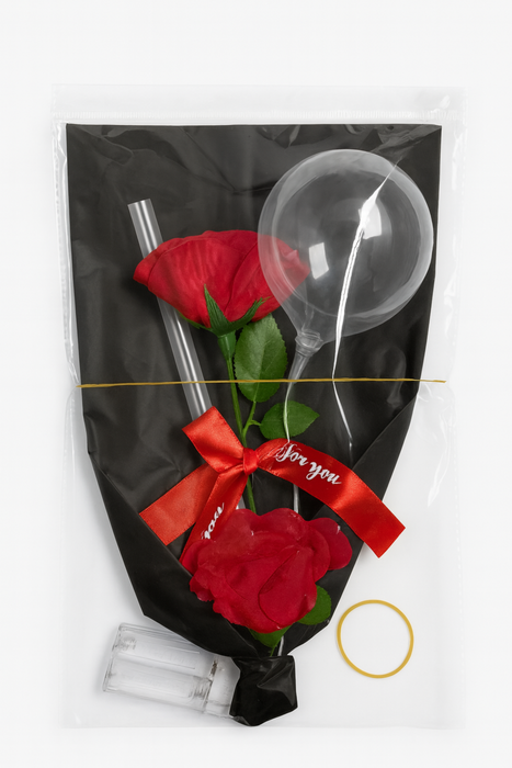 Gourmet gift set with red roses, straws, and a spoon in a black bag with a red bow.