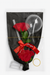 Gourmet gift set with red roses, straws, and a spoon in a black bag with a red bow.
