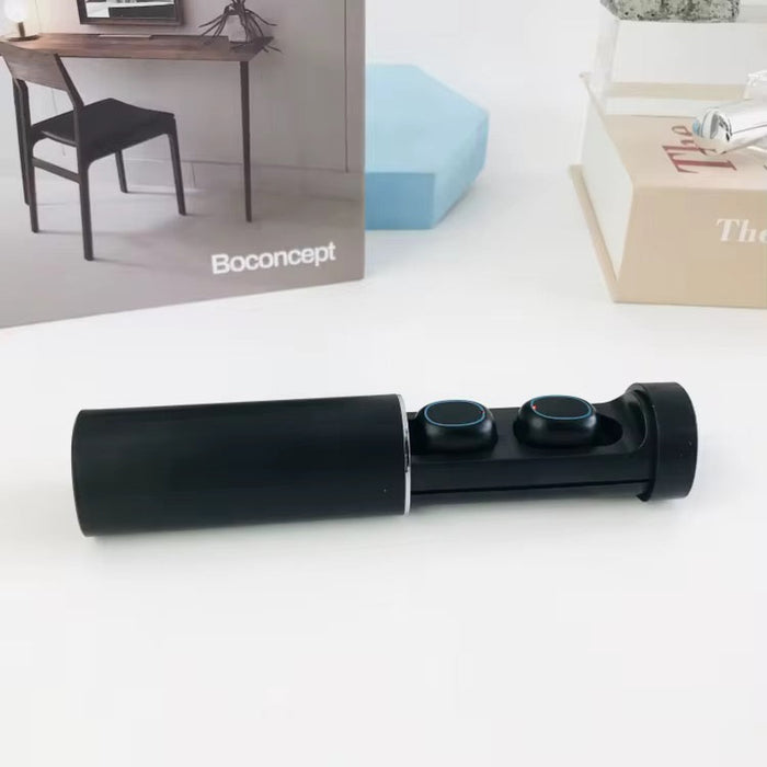 Black wireless earbuds on a white surface with Boconcept branding in the background.