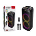 Black multimedia speaker with packaging, remote control, and microphones on a white background