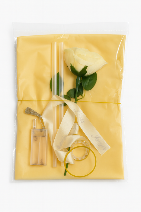Gift wrapped in yellow paper with a rose and ribbons on a white background