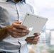 Person holding a white Apple iPad with a clear case.