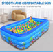 Children playing in an inflatable pool with colorful balls in a room.