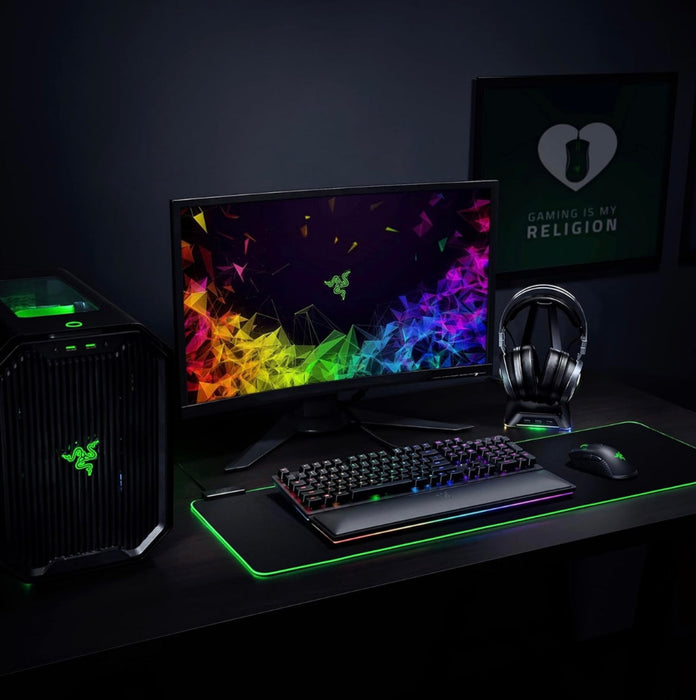 Gaming setup with monitor, keyboard, mouse, and headset on a dark surface.