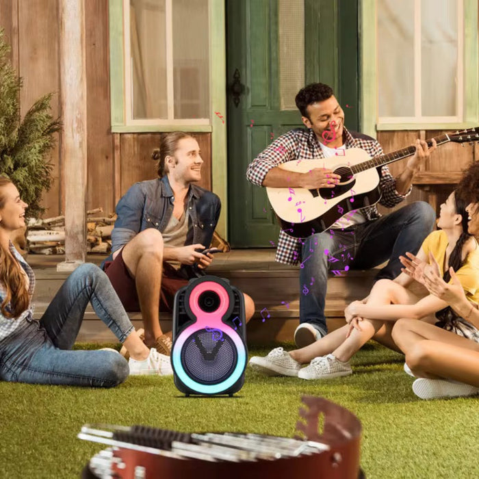 Group of friends enjoying music outdoors with a portable speaker and guitar.