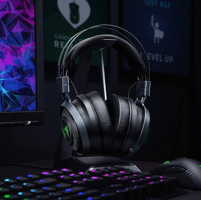 Gaming headset on a desk with a computer setup in the background