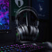 Gaming headset on a desk with a computer setup in the background