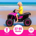 Child riding a pink and black toy ATV on a beach with ocean view